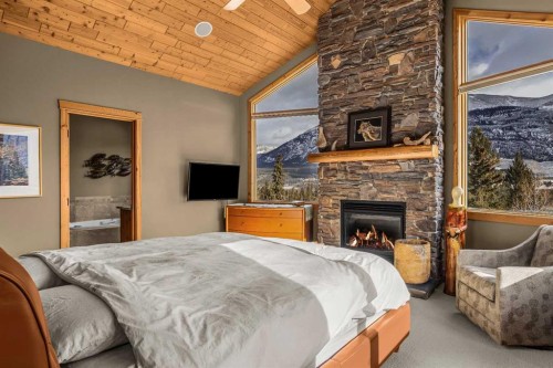 116-210 Hubman Landing, Canmore, AB - Indoor Photo Showing Bedroom With Fireplace