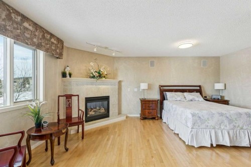 22 Valley Creek Road Nw, Calgary, AB - Indoor Photo Showing Bedroom With Fireplace