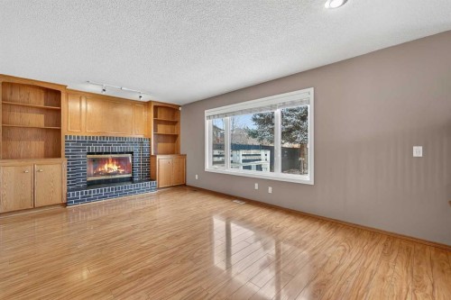 1208 Sunvista Way Se, Calgary, AB - Indoor Photo Showing Living Room With Fireplace