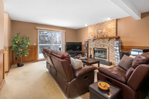 124 Strathbury Circle Sw, Calgary, AB - Indoor Photo Showing Living Room With Fireplace