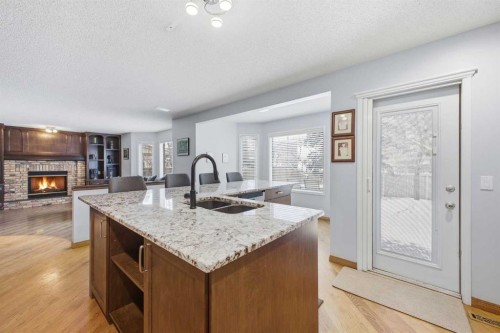 46 Sunset Way Se, Calgary, AB - Indoor Photo Showing Kitchen With Fireplace With Double Sink