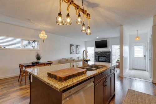 112 Fireside Drive, Cochrane, AB - Indoor Photo Showing Kitchen With Fireplace With Double Sink