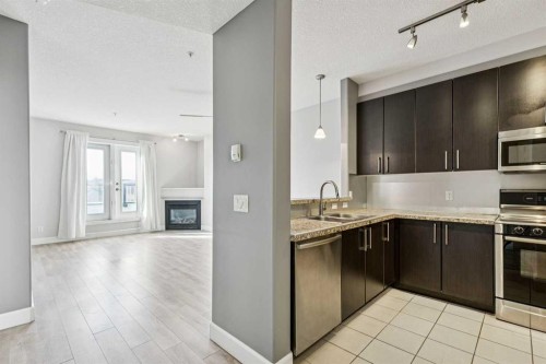 403-830 Centre Avenue Ne, Calgary, AB - Indoor Photo Showing Kitchen With Fireplace With Double Sink