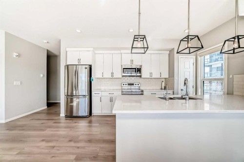 209-4250 Seton Drive Se, Calgary, AB - Indoor Photo Showing Kitchen With Stainless Steel Kitchen With Double Sink With Upgraded Kitchen