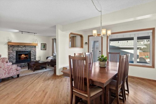 31 River Rock Manor Se, Calgary, AB - Indoor Photo Showing Dining Room With Fireplace