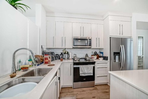 604-280 Chelsea Road, Chestermere, AB - Indoor Photo Showing Kitchen With Stainless Steel Kitchen With Double Sink With Upgraded Kitchen