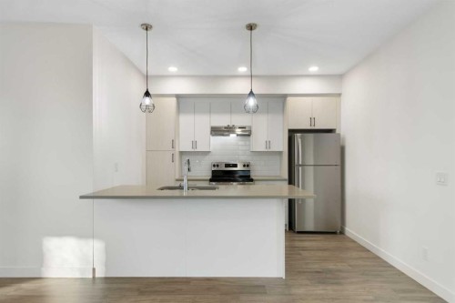 404-24 Rivercrest Drive, Cochrane, AB - Indoor Photo Showing Kitchen With Double Sink With Upgraded Kitchen