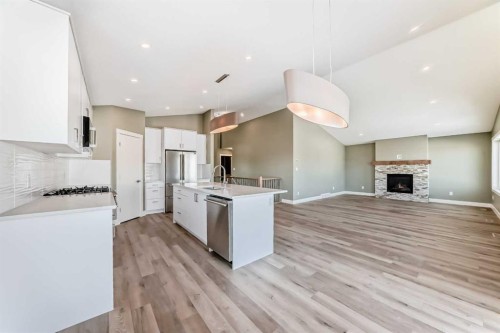 2017 30 Avenue, Nanton, AB - Indoor Photo Showing Kitchen With Fireplace