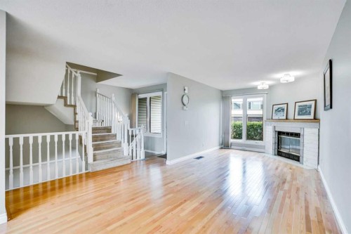 219 Coachway Lane Sw, Calgary, AB - Indoor Photo Showing Living Room With Fireplace