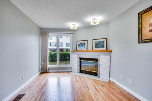 219 Coachway Lane Sw, Calgary, AB - Indoor Photo Showing Living Room With Fireplace