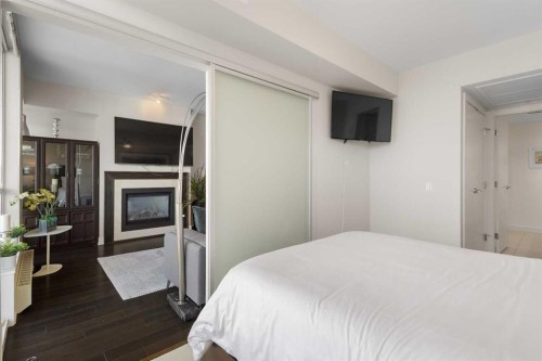 1322-222 Riverfront Avenue Sw, Calgary, AB - Indoor Photo Showing Bedroom With Fireplace