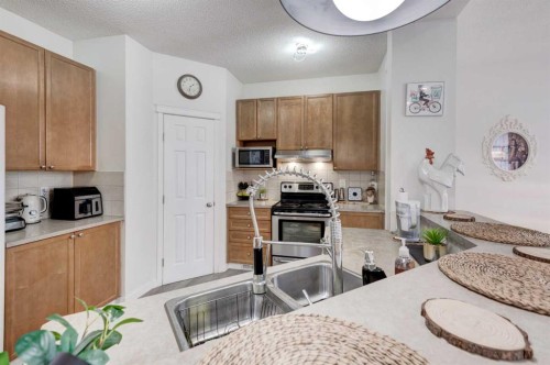 52 Bridlemeadows Common Sw, Calgary, AB - Indoor Photo Showing Kitchen With Double Sink