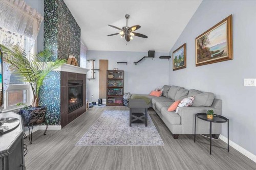 301 Mcleod Crescent, Diamond Valley, AB - Indoor Photo Showing Living Room With Fireplace