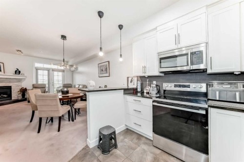 211-1005A Westmount Drive, Strathmore, AB - Indoor Photo Showing Kitchen With Fireplace