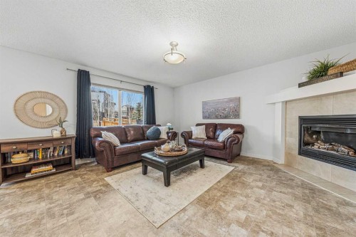 31 Jumping Pound Rise, Cochrane, AB - Indoor Photo Showing Living Room With Fireplace