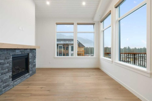402-1505 Spring Creek Gate, Canmore, AB - Indoor Photo Showing Living Room With Fireplace