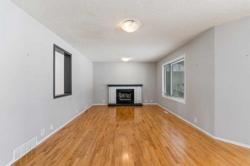 9 Mckenzie Place Se, Calgary, AB - Indoor Photo Showing Living Room With Fireplace