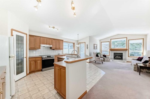 220 Rocky Ridge Villas Nw, Calgary, AB - Indoor Photo Showing Kitchen With Fireplace