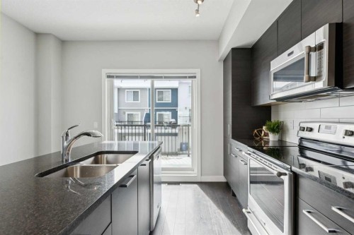 2506 Jumping Pound Common, Cochrane, AB - Indoor Photo Showing Kitchen With Stainless Steel Kitchen With Double Sink With Upgraded Kitchen