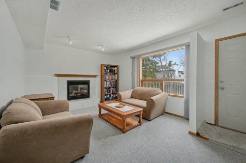 16 Straddock Crescent Sw, Calgary, AB - Indoor Photo Showing Living Room With Fireplace