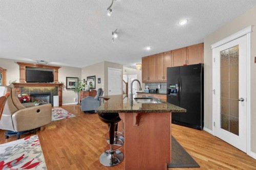 155 Morningside Circle Sw, Airdrie, AB - Indoor Photo Showing Kitchen With Fireplace