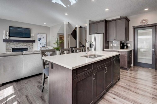 255 Riviera Way, Cochrane, AB - Indoor Photo Showing Kitchen With Fireplace With Double Sink