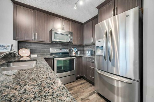 731-101 Sunset Drive, Cochrane, AB - Indoor Photo Showing Kitchen With Stainless Steel Kitchen With Double Sink