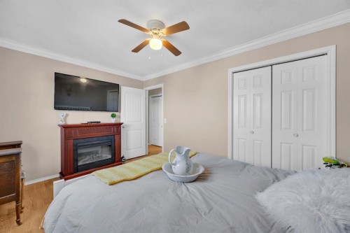 36 Alpine Crescent Se, Airdrie, AB - Indoor Photo Showing Bedroom With Fireplace