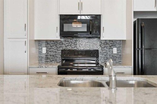 9205-101 Sunset Drive, Cochrane, AB - Indoor Photo Showing Kitchen With Double Sink With Upgraded Kitchen