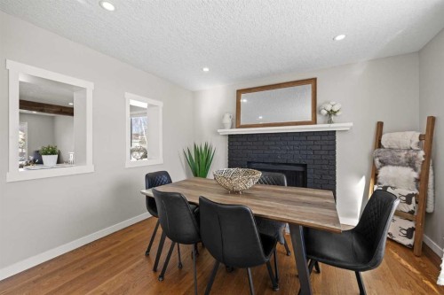 23 Millbank Drive Sw, Calgary, AB - Indoor Photo Showing Dining Room With Fireplace