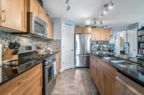 61 Drake Landing Loop, Okotoks, AB - Indoor Photo Showing Kitchen With Stainless Steel Kitchen With Double Sink With Upgraded Kitchen