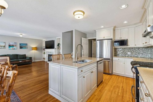 107 Sheep River Bay, Okotoks, AB - Indoor Photo Showing Kitchen With Stainless Steel Kitchen With Double Sink With Upgraded Kitchen