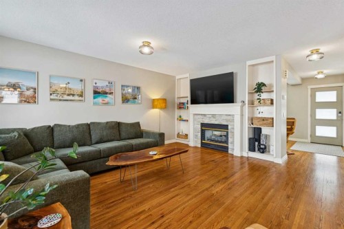 107 Sheep River Bay, Okotoks, AB - Indoor Photo Showing Living Room With Fireplace