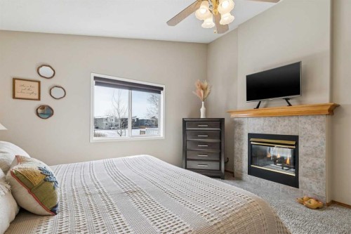 113 Westchester Way, Chestermere, AB - Indoor Photo Showing Bedroom With Fireplace