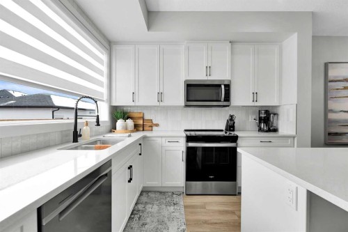125 Emberside Hollow, Cochrane, AB - Indoor Photo Showing Kitchen With Double Sink