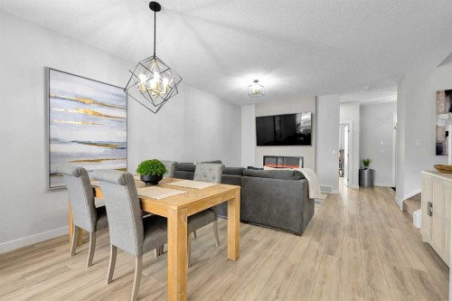 125 Emberside Hollow, Cochrane, AB - Indoor Photo Showing Dining Room With Fireplace
