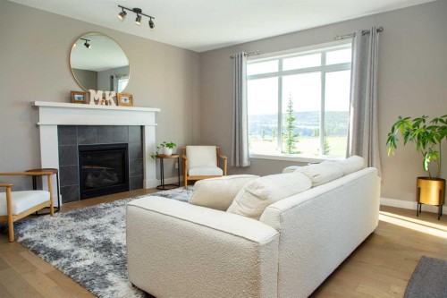 128 Sundown View, Cochrane, AB - Indoor Photo Showing Living Room With Fireplace