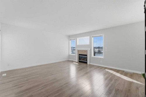1-12 Silver Creek Boulevard Nw, Airdrie, AB - Indoor Photo Showing Other Room With Fireplace