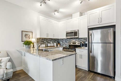 1502 Jumping Pound Common, Cochrane, AB - Indoor Photo Showing Kitchen With Stainless Steel Kitchen With Double Sink With Upgraded Kitchen
