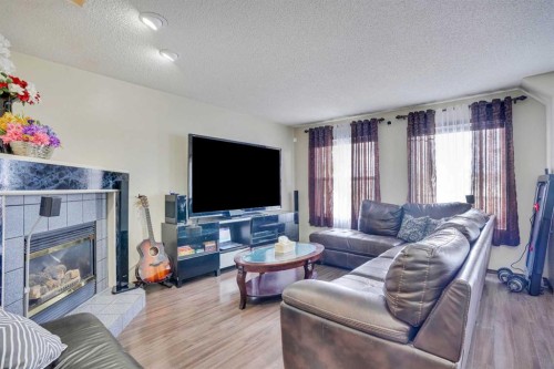 83 Bridlecreek Heath Sw, Calgary, AB - Indoor Photo Showing Living Room With Fireplace