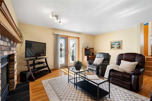 221 Scurfield Place Nw, Calgary, AB - Indoor Photo Showing Living Room With Fireplace