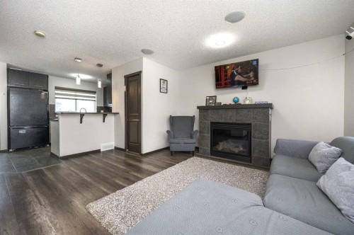 702 Panamount Boulevard Nw, Calgary, AB - Indoor Photo Showing Living Room With Fireplace