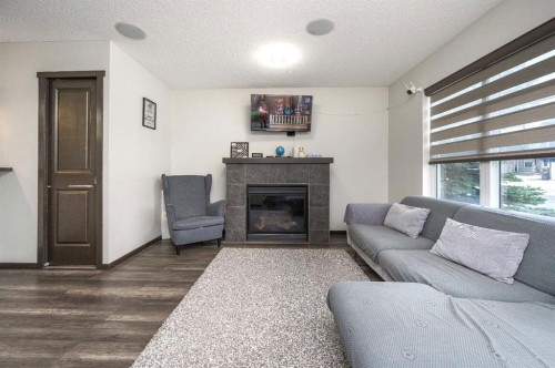 702 Panamount Boulevard Nw, Calgary, AB - Indoor Photo Showing Living Room With Fireplace