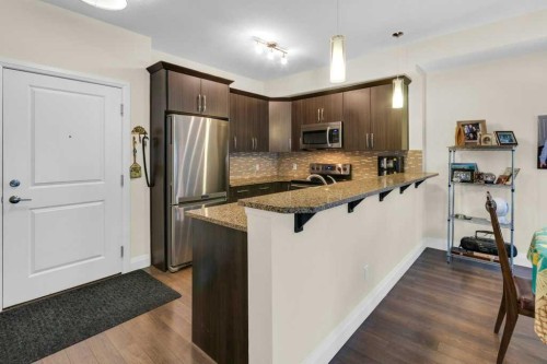 2104-15 Sunset Square, Cochrane, AB - Indoor Photo Showing Kitchen With Stainless Steel Kitchen With Upgraded Kitchen