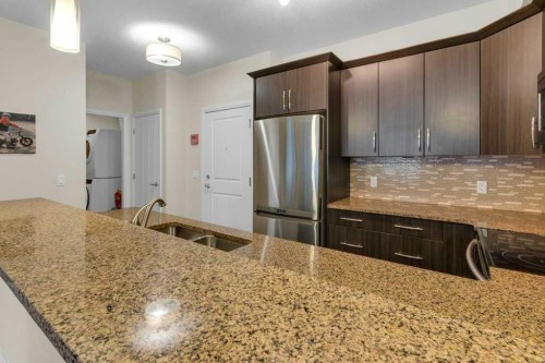 2104-15 Sunset Square, Cochrane, AB - Indoor Photo Showing Kitchen With Stainless Steel Kitchen With Double Sink