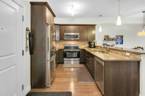 2104-15 Sunset Square, Cochrane, AB - Indoor Photo Showing Kitchen With Stainless Steel Kitchen With Double Sink With Upgraded Kitchen