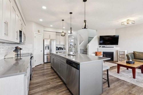 57 Crestridge Bay Sw, Calgary, AB - Indoor Photo Showing Kitchen With Fireplace With Stainless Steel Kitchen With Double Sink With Upgraded Kitchen