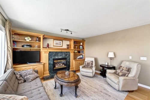 219 Hidden Ranch Circle Nw, Calgary, AB - Indoor Photo Showing Living Room With Fireplace