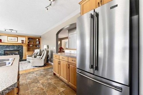219 Hidden Ranch Circle Nw, Calgary, AB - Indoor Photo Showing Kitchen With Fireplace With Stainless Steel Kitchen