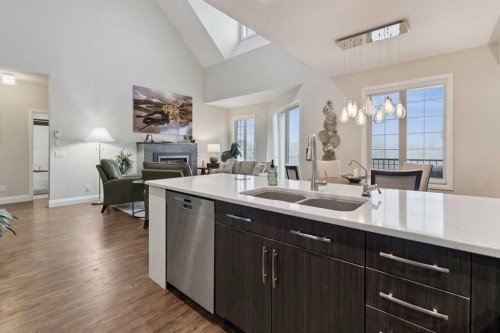 2410-15 Sunset Square, Cochrane, AB - Indoor Photo Showing Kitchen With Fireplace With Double Sink